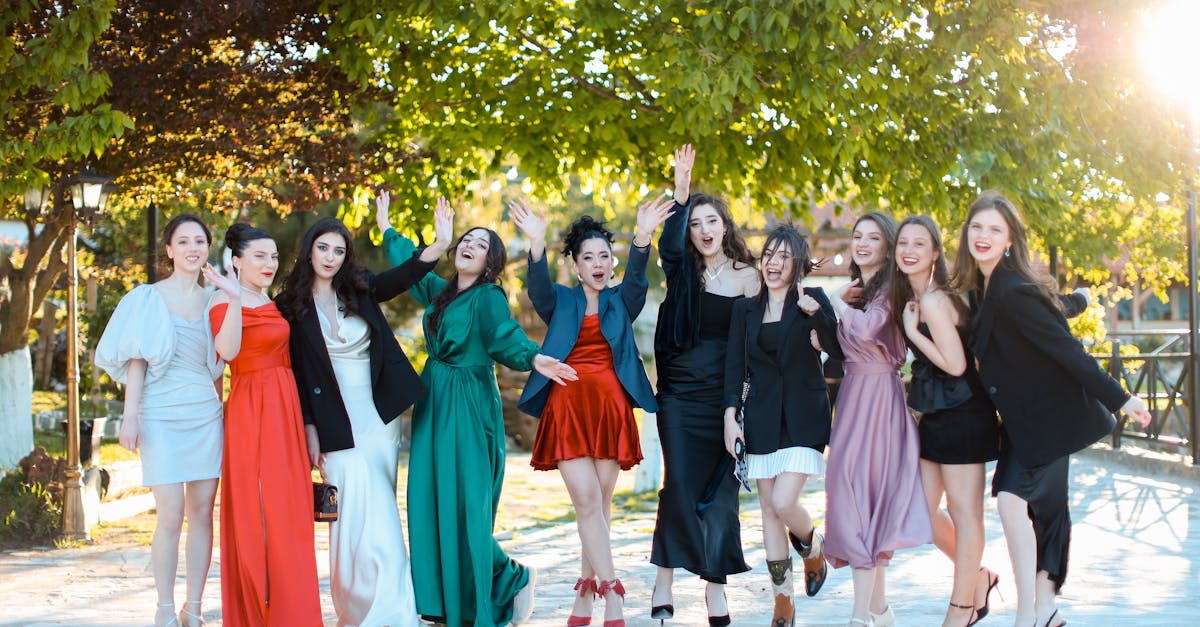 Group of well-dressed young women enjoying a celebration outdoors, exuding joy and friendship.